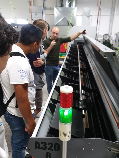 4 high school students listen and watch a Decker Machine Co employee show equipment